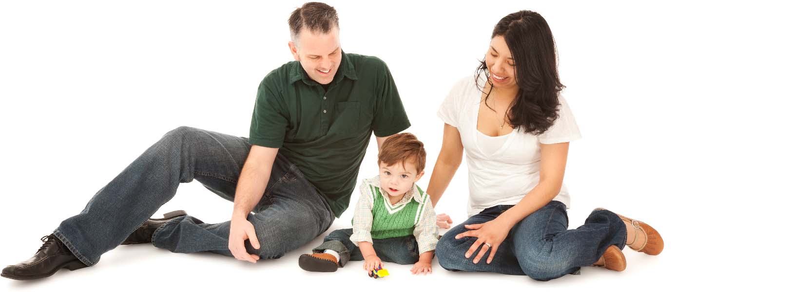 Photo of a happy foster family sitting on the floor with their toddler that is playing with his yellow excavator toy.